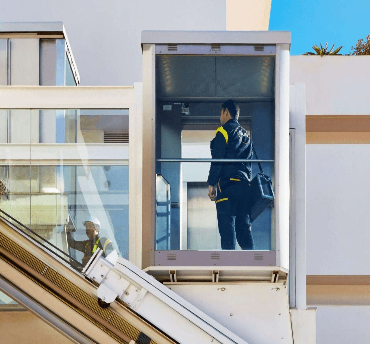 Technicien dans un ascenseur panoramique.